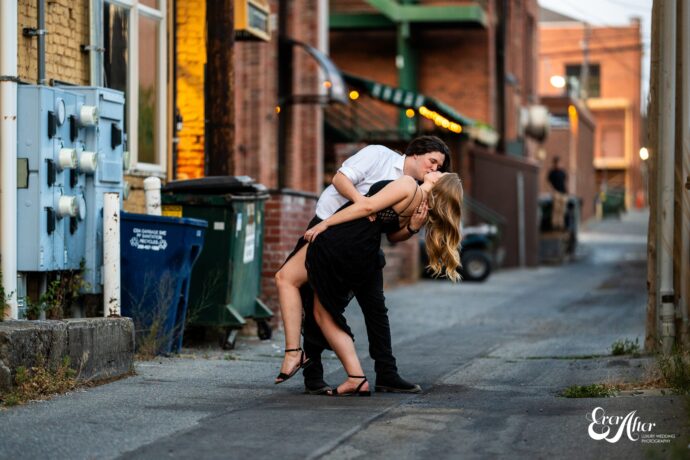 groom dipping his bride in an alleyway