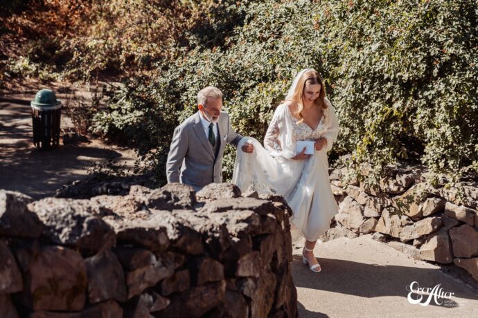 Dad walking the bride up stone steps