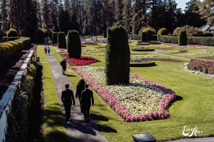 groom and groomsmen walking through a Flower garden