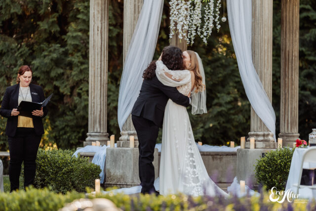 Bride and groom kissing at the alter