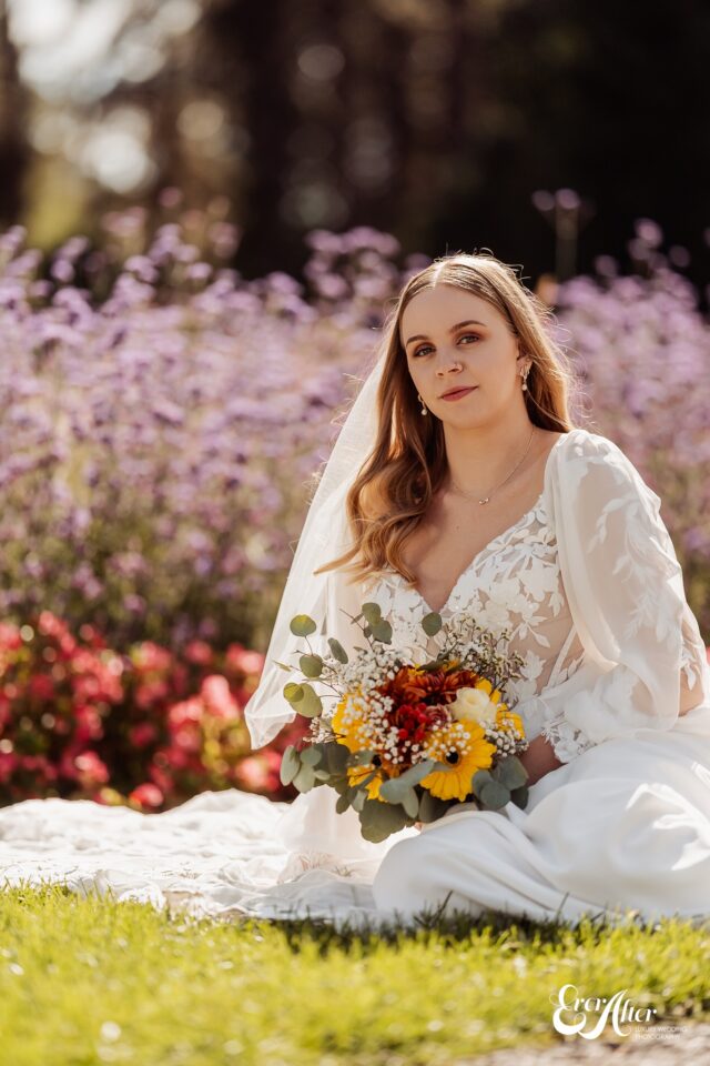 Bride stoically posing in front of flowers Bride stoically posing in front of flowers